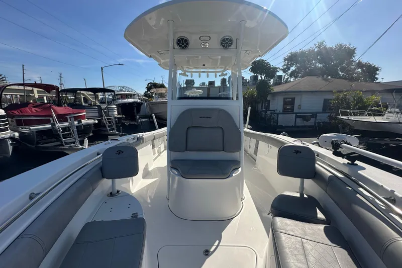 Slide: The Image of 2020 Sea Pro 239 Center Console boat with seating, docked under clear blue sky. - 13
