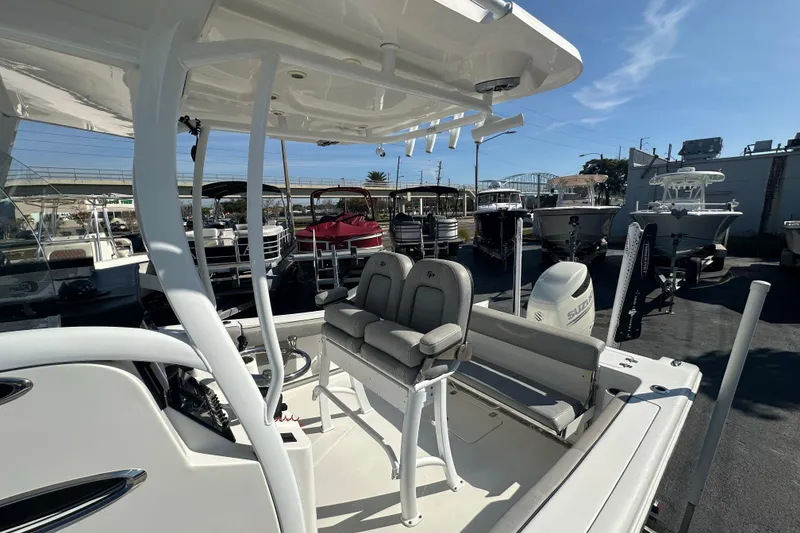 Slide: The Image of 2020 Sea Pro 239 Center Console boat interior with seating and console, parked outdoors. - 26