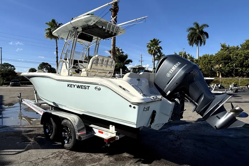 Slide: The Image of 2021 Key West 239 FS boat on trailer with Yamaha engine, parked outdoors. - 3