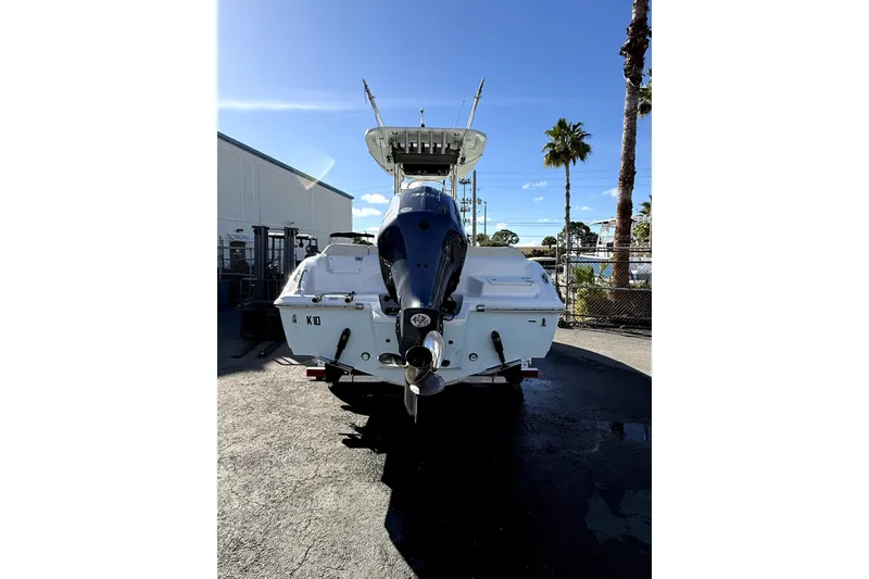 Slide: The Image of 2021 Key West 239 FS boat, rear view, parked outdoors under clear blue sky. - 5