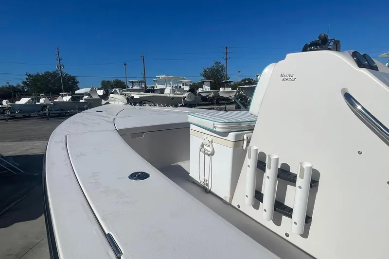 Slide: The Image of 2004 Maverick Master Angler 18 boat, white deck, rod holders, and seating, in a marina. - 3