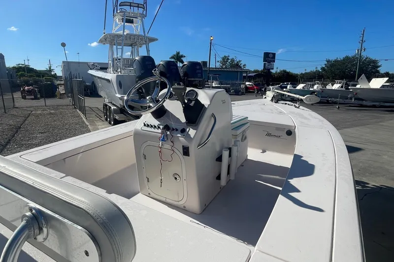 Slide: The Image of 2004 Maverick Master Angler 18 boat with center console, parked in a marina under clear blue sky. - 6