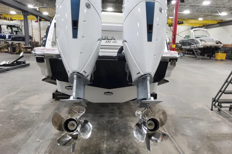 Slide: The Image of 2026 Formula 330 Crossover Bowrider OB with dual outboard engines in a workshop. - 14