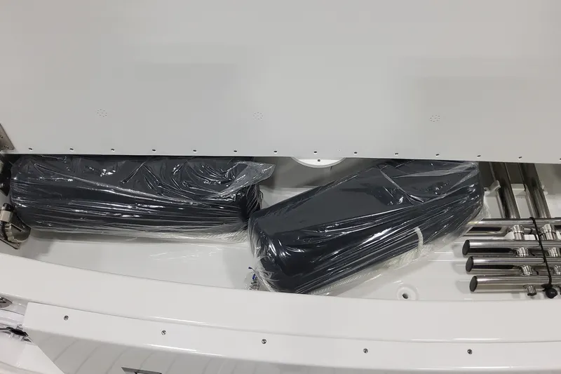 Slide: The Image of Storage compartment of 2026 Formula 330 Crossover Bowrider OB with wrapped items and metal rods. - 23