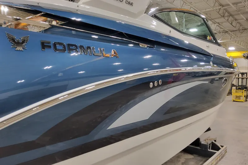 Slide: The Image of 2026 Formula 330 Crossover Bowrider OB in a showroom, showcasing sleek blue design. - 4