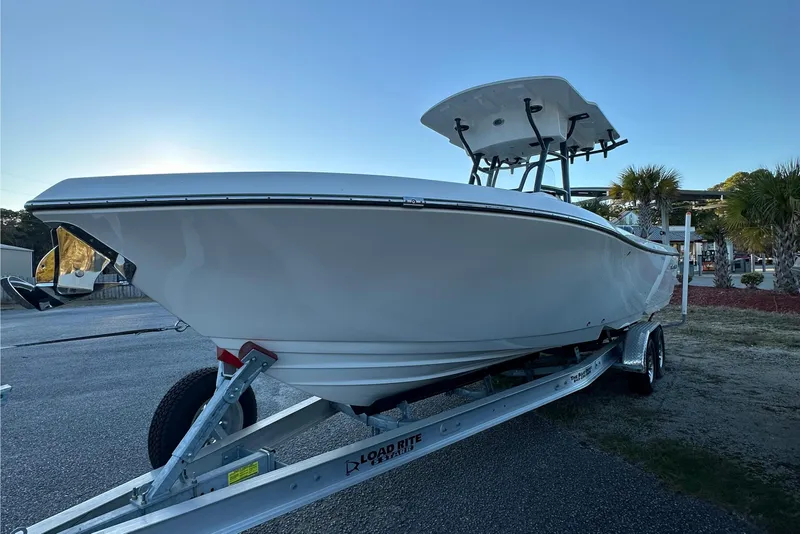 Slide: The Image of 2024 Sea Born LX 26 LE boat on trailer, parked outdoors under clear sky. - 9