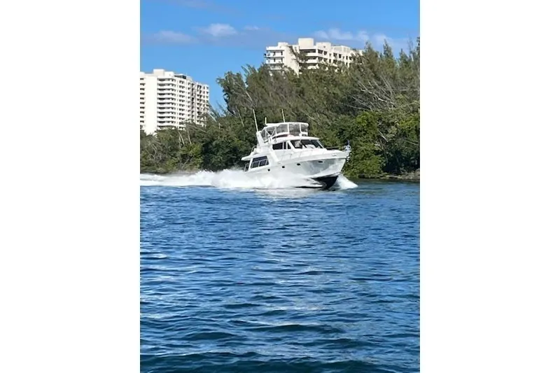 Slide: The Image of 2007 Pama 540 LX Pilothouse cruising on a sunny day near waterfront buildings. - 13