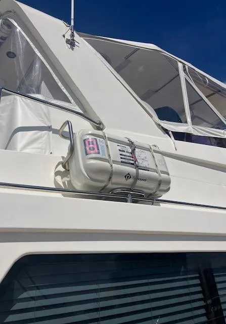 Slide: The Image of 2007 Pama 540 LX Pilothouse yacht with life raft, white exterior, and clear blue sky. - 43