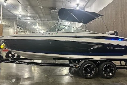 Slide: The Image of 2024 Crownline 240 SS boat on trailer in indoor showroom. - 2