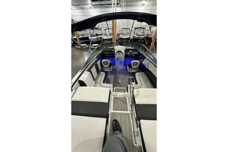 Slide: The Image of 2024 Crownline 240 SS boat interior with modern seating and blue ambient lighting. - 9