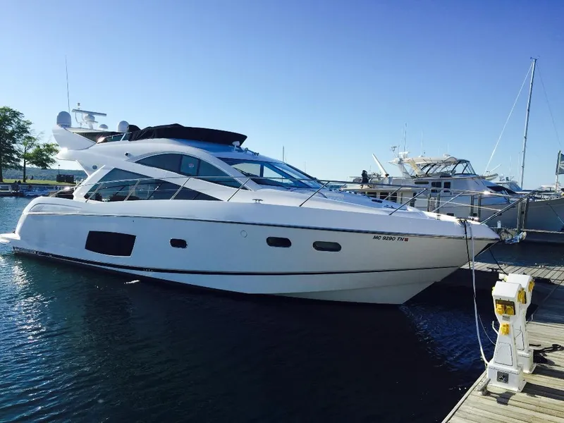 The Image of 2014 Sunseeker Manhattan 53 yacht docked at marina under clear blue sky. - 0