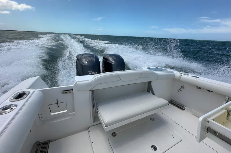 Slide: The Image of 2015 Everglades 295 Center Console boat cruising on open water with twin engines. - 17