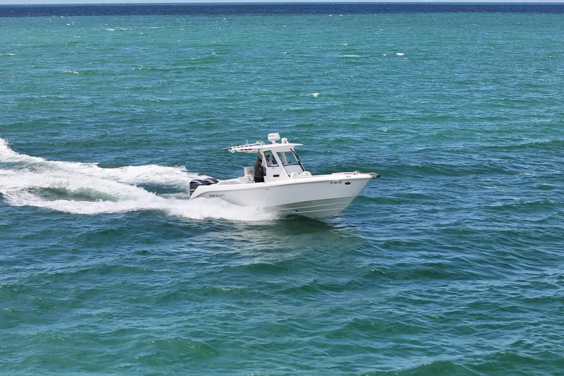 Slide: The Image of 2015 Everglades 295 Center Console boat cruising on open blue water. - 2