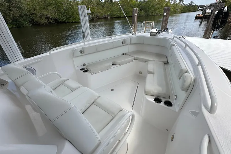 Slide: The Image of 2015 Everglades 295 Center Console boat interior with white seating and cup holders. - 24