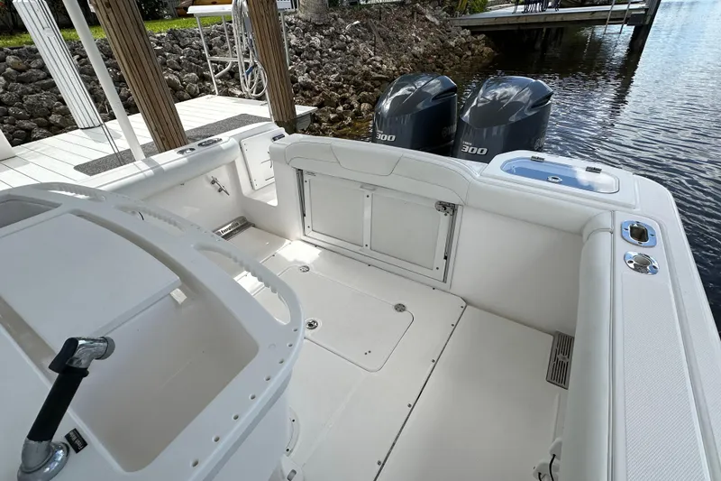 Slide: The Image of 2015 Everglades 295 Center Console boat with dual engines docked by water. - 26
