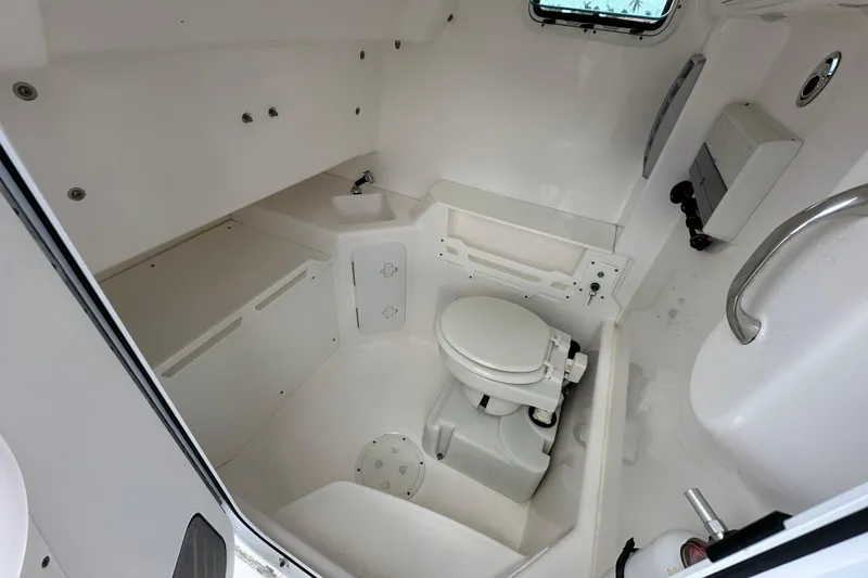 Slide: The Image of 2015 Everglades 295 Center Console boat interior with compact marine toilet. - 33