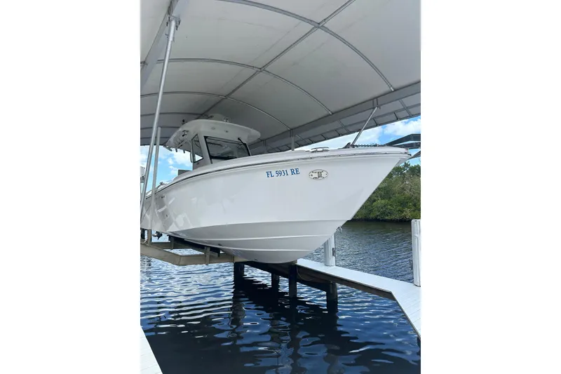 Slide: The Image of 2015 Everglades 295 Center Console boat docked under a canopy. - 50
