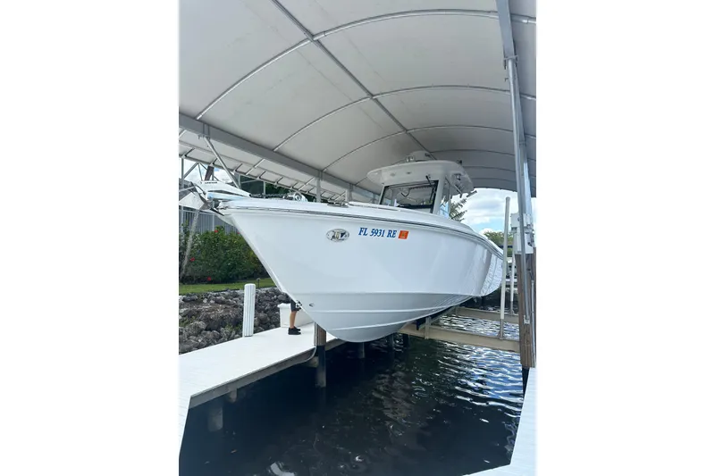 Slide: The Image of 2015 Everglades 295 Center Console boat docked under a canopy. - 53