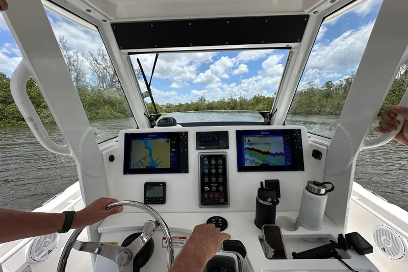 Slide: The Image of Interior view of 2015 Everglades 295 Center Console boat with navigation screens and steering wheel. - 54