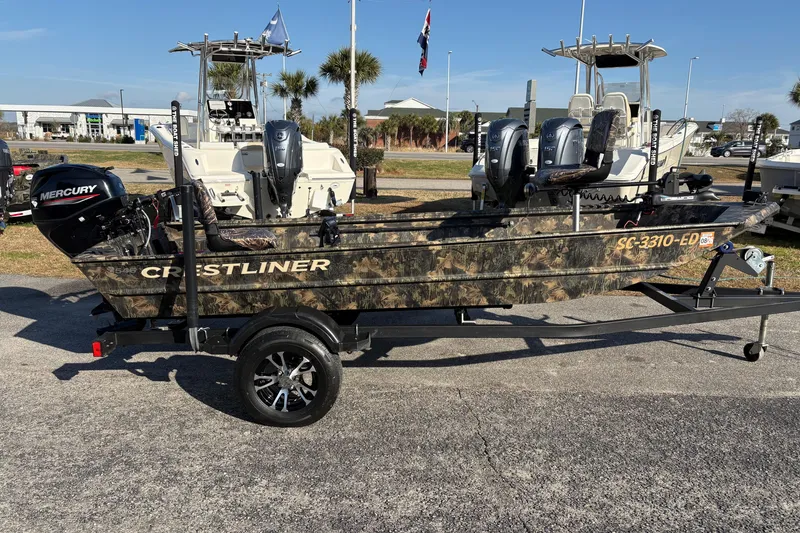 Slide: The Image of 2022 Crestliner 1546 Retriever boat with camouflage design on a trailer, featuring a Mercury outboard motor. - 10