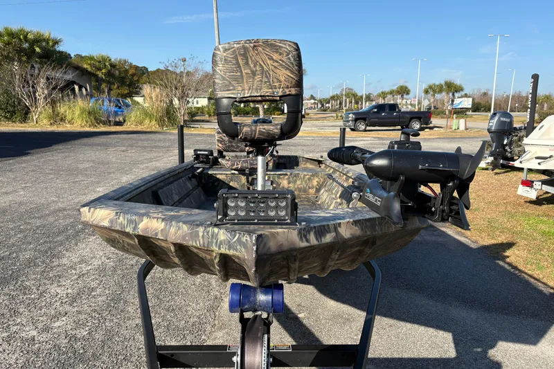 Slide: The Image of 2022 Crestliner 1546 Retriever boat with camouflage design, parked outdoors. - 12