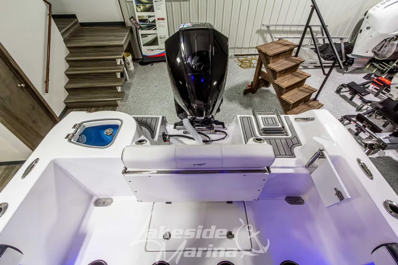 Slide: The Image of 2026 Tidewater 210 CC Adventure boat interior with motor, displayed in showroom. - 12