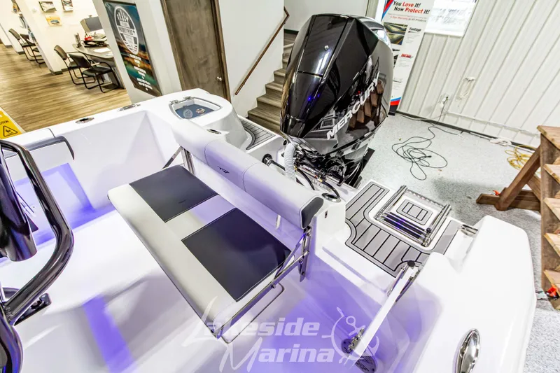 Slide: The Image of 2026 Tidewater 210 CC Adventure boat with Mercury engine, showcased indoors. - 15