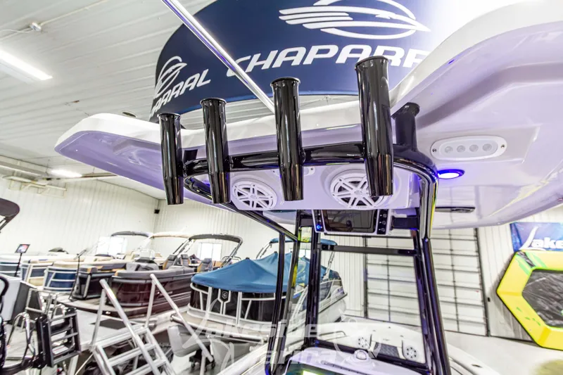 Slide: The Image of 2026 Tidewater 210 CC Adventure boat interior with rod holders and speakers in showroom. - 20