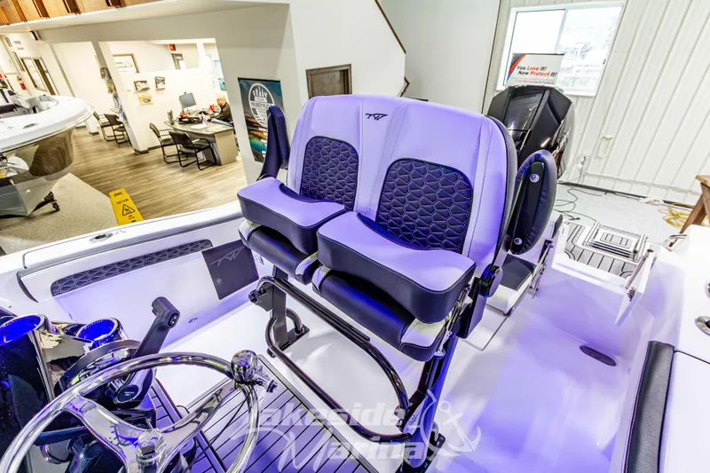 Slide: The Image of 2026 Tidewater 210 CC Adventure boat interior with modern seating and steering wheel. - 25