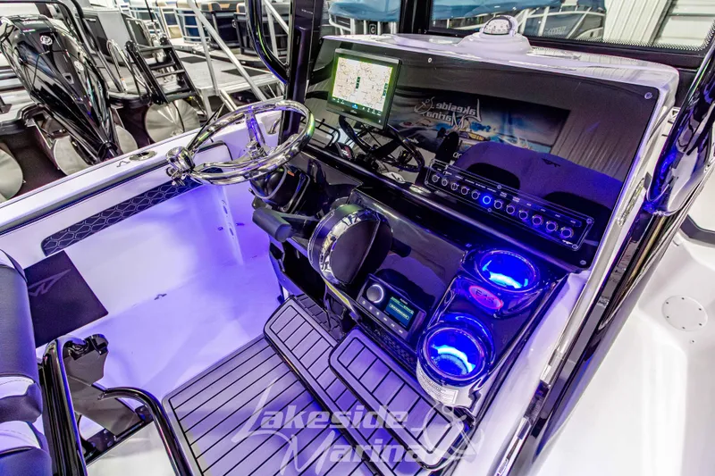 Slide: The Image of 2026 Tidewater 210 CC Adventure boat cockpit with modern controls and illuminated cup holders. - 27