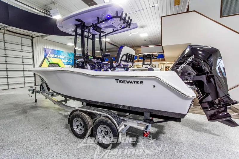 Slide: The Image of 2026 Tidewater 210 CC Adventure boat on trailer in showroom, featuring Mercury outboard engine. - 7