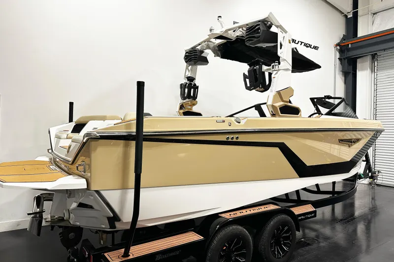 Slide: The Image of 2025 Nautique Super Air Nautique S23 boat in showroom, featuring sleek design and modern features. - 2