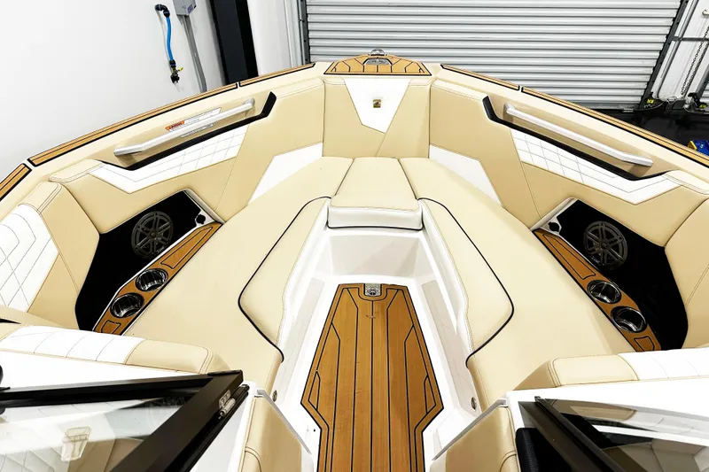 Slide: The Image of 2025 Nautique Super Air Nautique S23 boat interior with tan seating and wood accents. - 4