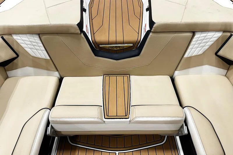 Slide: The Image of 2025 Nautique Super Air Nautique S23 interior with luxurious beige seating and wood accents. - 6