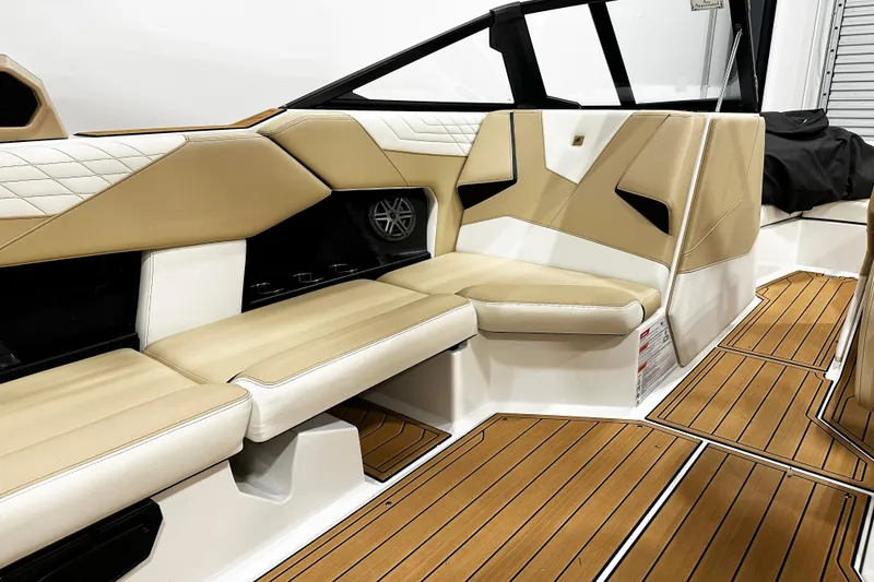 Slide: The Image of 2025 Nautique Super Air Nautique S23 interior with tan and white seating, teak flooring. - 7