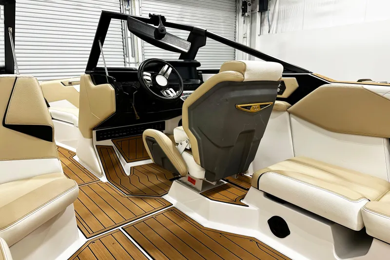Slide: The Image of 2025 Nautique Super Air Nautique S23 interior with beige seating and wood accents. - 8