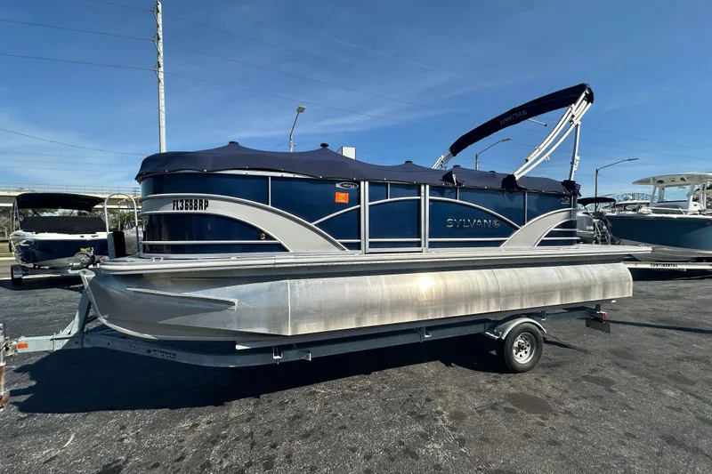 Slide: The Image of 2018 Sylvan Mirage Cruise 8520 pontoon boat on trailer, blue and silver design. - 1