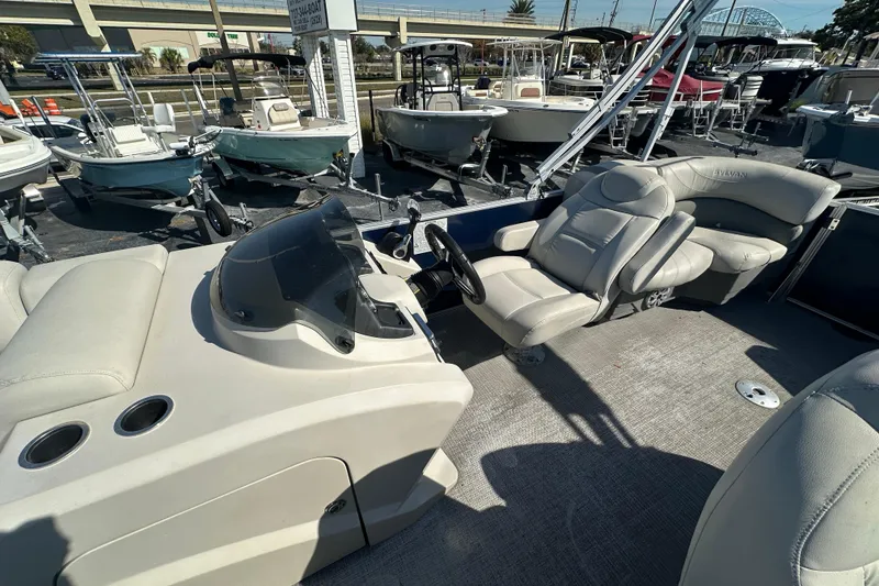 Slide: The Image of 2018 Sylvan Mirage Cruise 8520 boat interior with steering console and seating. - 12