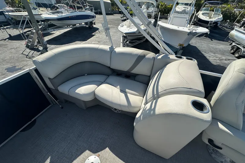 Slide: The Image of 2018 Sylvan Mirage Cruise 8520 boat interior with cushioned seating and cup holders. - 17