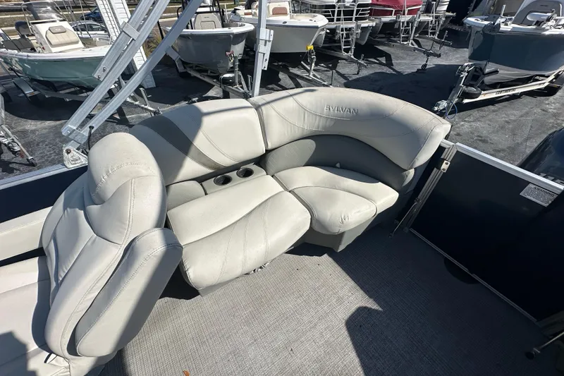 Slide: The Image of 2018 Sylvan Mirage Cruise 8520 boat interior with plush seating and cup holders. - 18