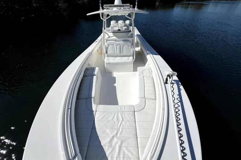 Slide: The Image of 2018 Regulator 34 Center Console boat on calm water, showcasing spacious seating and sleek design. - 16