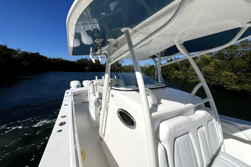 Slide: The Image of 2018 Regulator 34 Center Console boat cruising on a scenic waterway. - 20