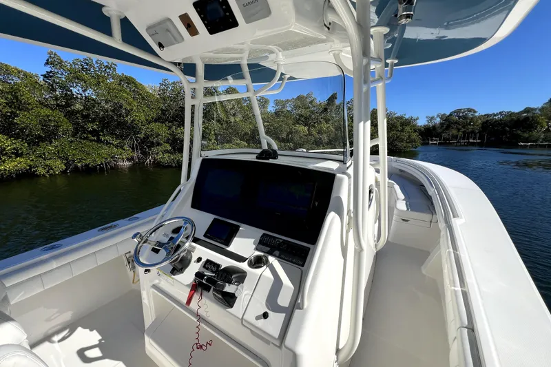 Slide: The Image of 2018 Regulator 34 Center Console boat on calm water, featuring advanced navigation equipment. - 25