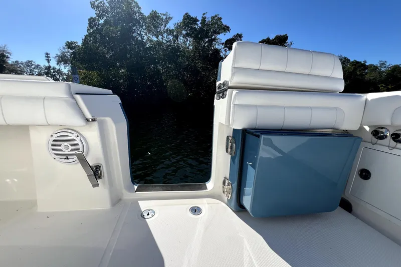Slide: The Image of 2018 Regulator 34 Center Console boat interior with seating and storage, surrounded by water and trees. - 35