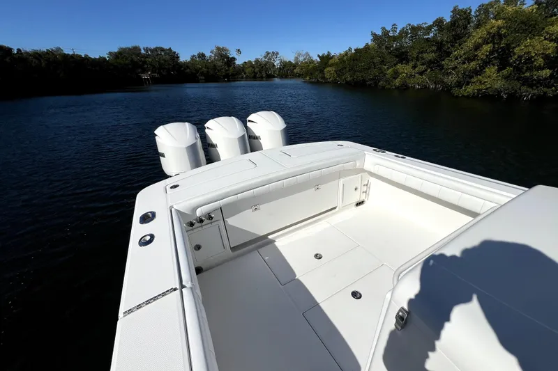 Slide: The Image of 2018 Regulator 34 Center Console boat with triple engines on a calm waterway. - 37