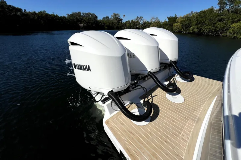 Slide: The Image of 2018 Regulator 34 Center Console with triple Yamaha outboard engines on water. - 45