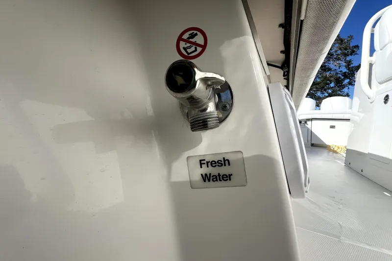 Slide: The Image of 2018 Regulator 34 Center Console boat with fresh water outlet and no smoking sign. - 48