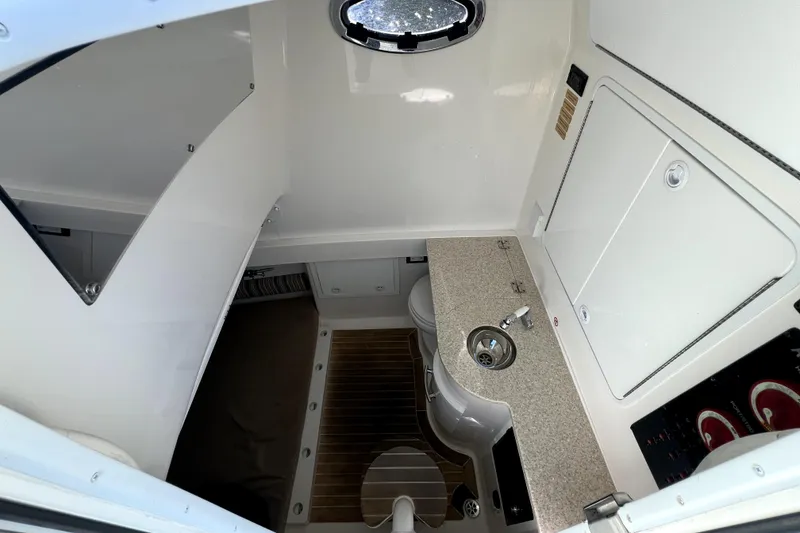 Slide: The Image of 2018 Regulator 34 Center Console cabin interior with sink and toilet. - 51