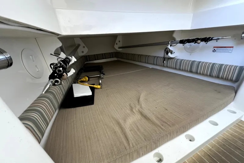 Slide: The Image of 2018 Regulator 34 Center Console cabin interior with fishing rods and striped cushions. - 52