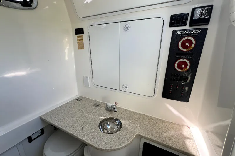 Slide: The Image of 2018 Regulator 34 Center Console interior with control panel and sink. - 53